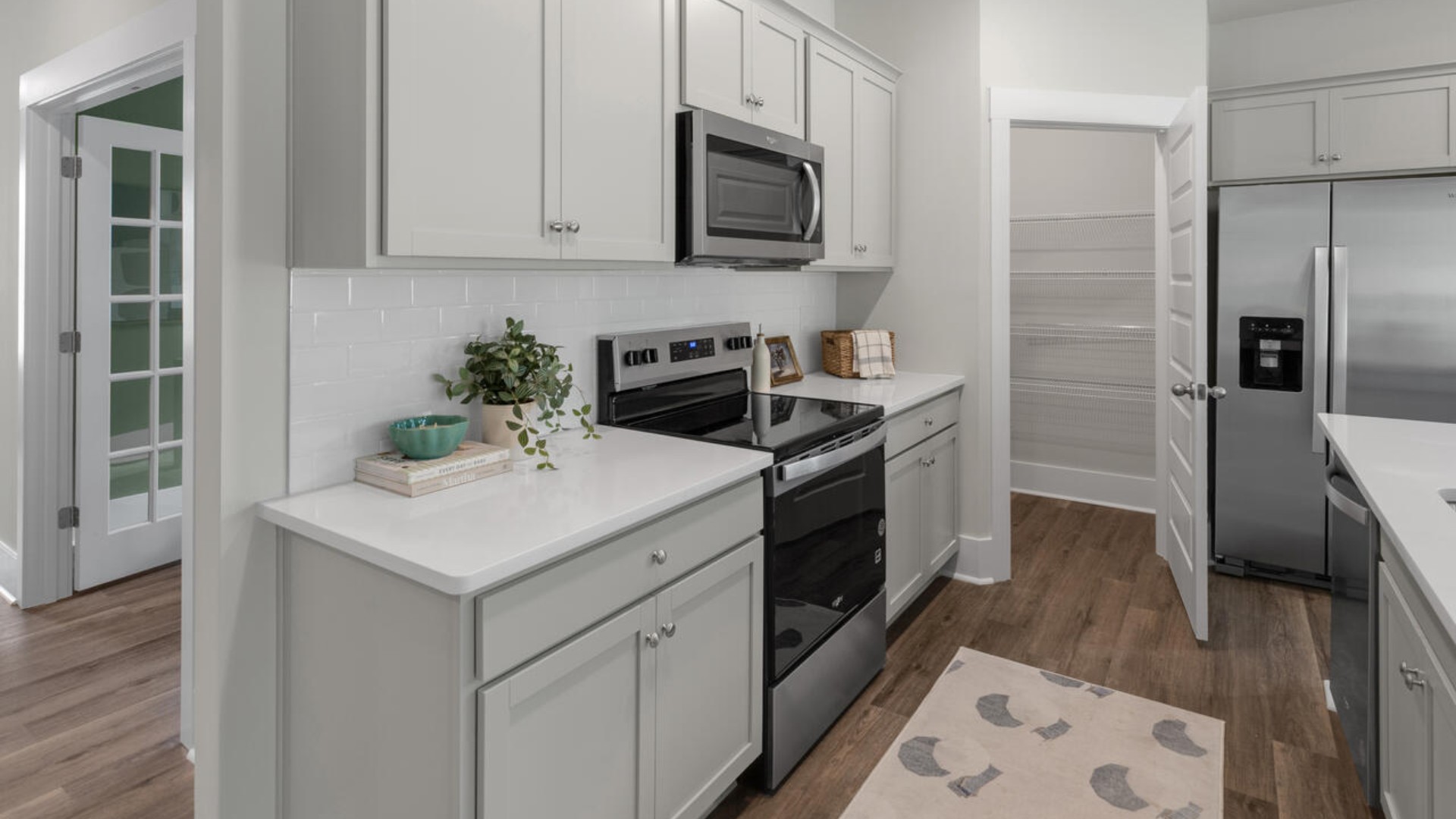 The kitchen features shaker-style cabinets, quartz countertops, and stainless steel appliances, which are sure to both turn heads and make meal prep easy. You’ll never be too far from the action with the living and dining area right there.