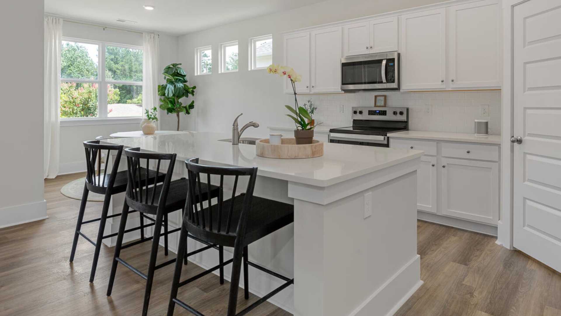 Enjoy coastal living at its best with a screened-in covered porch just off the open-concept kitchen, dining, and living areas — perfect for relaxing or entertaining. The kitchen boasts stainless steel appliances, a walk-in pantry, 4x12 subway tile, quartz countertops and a generous island that flows seamlessly into the main living area.