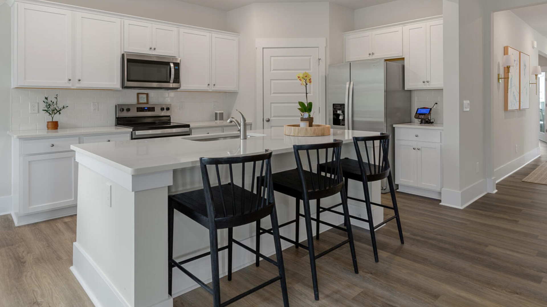 Enjoy coastal living at its best with a screened-in covered porch just off the open-concept kitchen, dining, and living areas — perfect for relaxing or entertaining. The kitchen boasts stainless steel appliances, a walk-in pantry, 4x12 subway tile, quartz countertops and a generous island that flows seamlessly into the main living area.