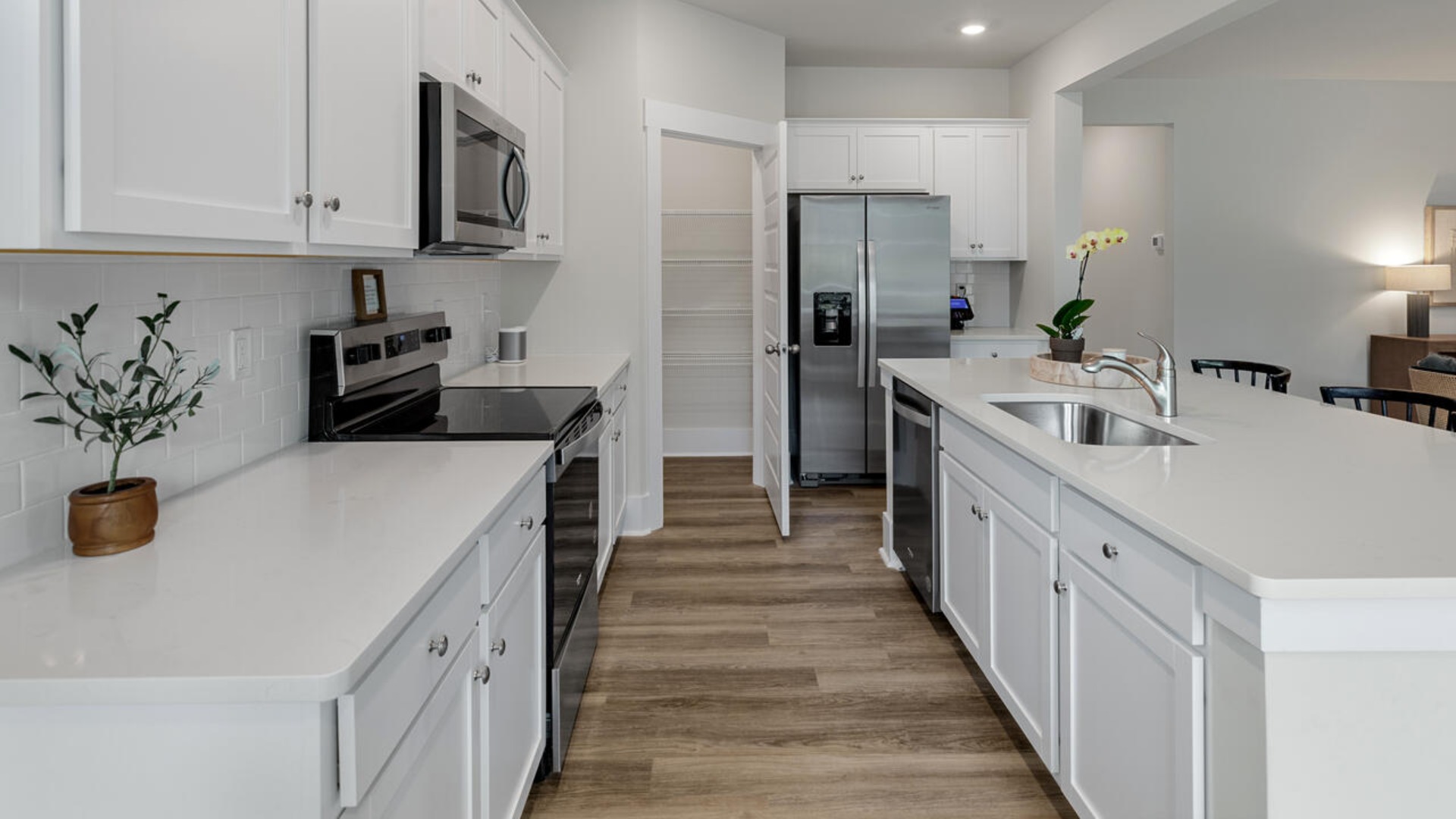 Enjoy coastal living at its best with a screened-in covered porch just off the open-concept kitchen, dining, and living areas — perfect for relaxing or entertaining. The kitchen boasts stainless steel appliances, a walk-in pantry, 4x12 subway tile, quartz countertops and a generous island that flows seamlessly into the main living area.