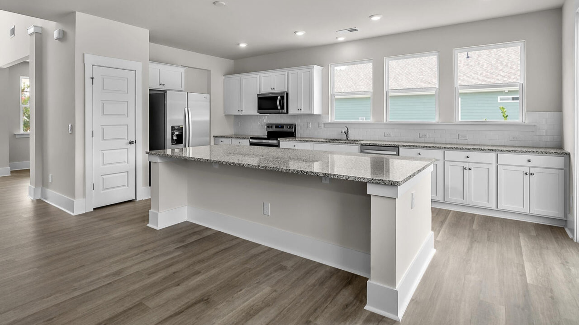The kitchen features shaker-style cabinets and beautiful quartz countertops. The kitchen island is the perfect size for meal prep with a built-in sink and dishwasher.