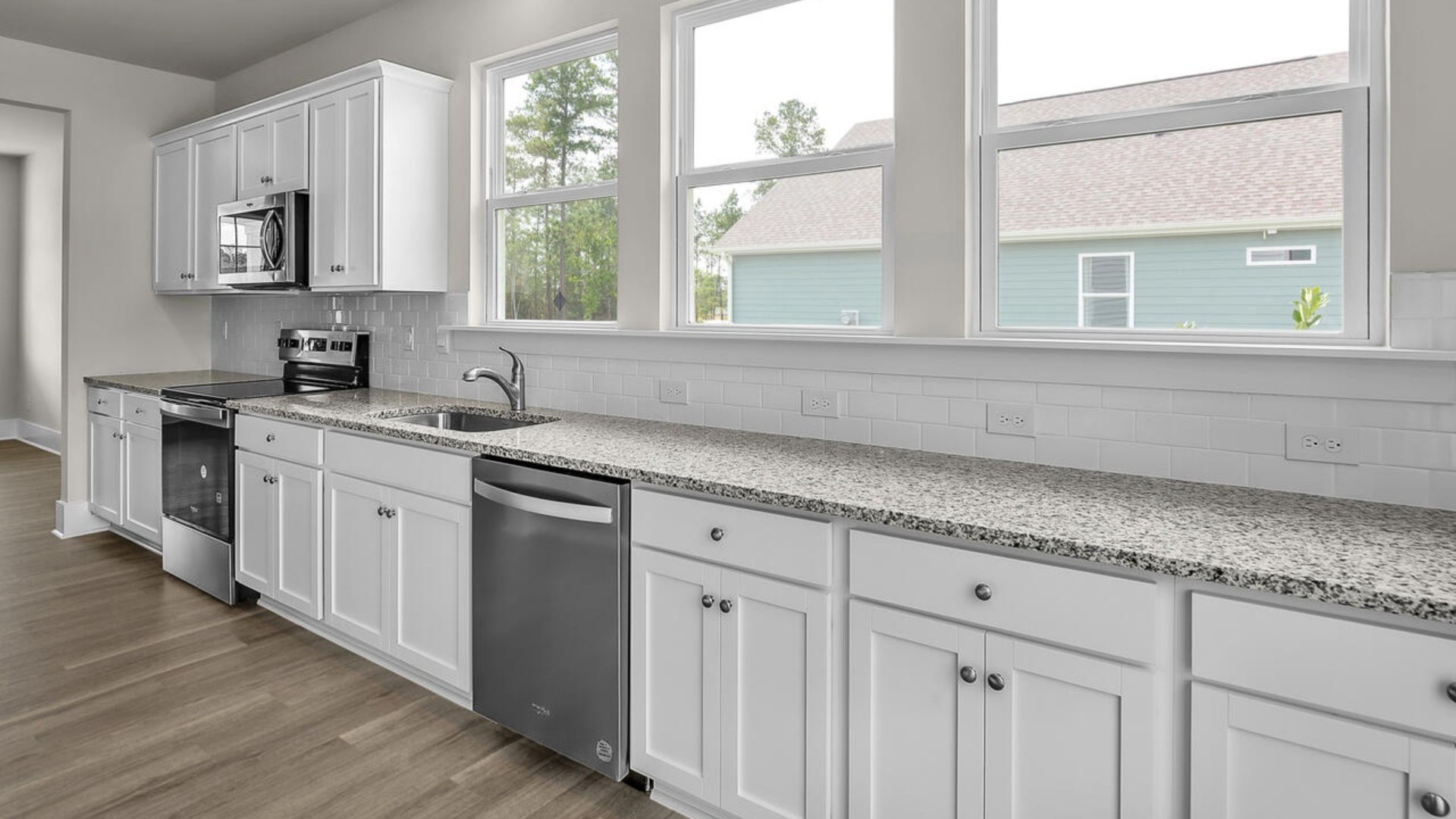 The kitchen features shaker-style cabinets and beautiful quartz countertops. The kitchen island is the perfect size for meal prep with a built-in sink and dishwasher.