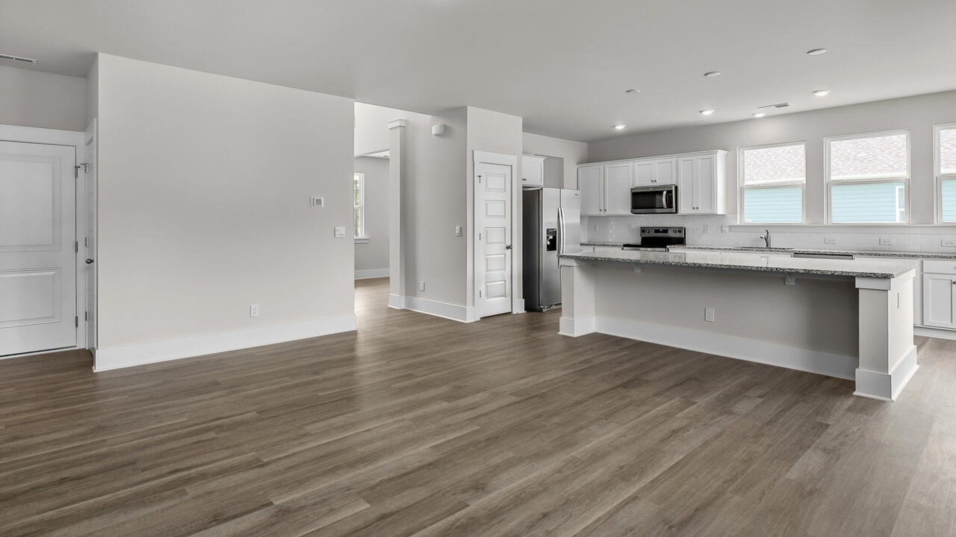 Featuring a formal dining room adjoining the kitchen, large island with granite countertops, and open concept living space.