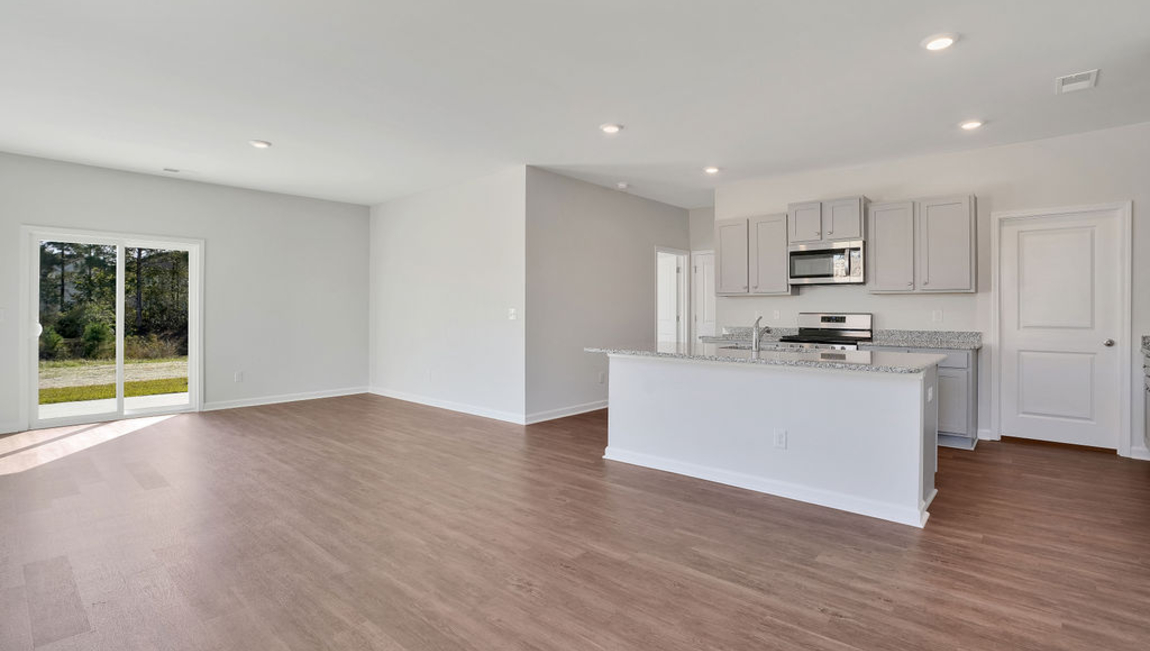 This new home kitchen features Stainless Steel Appliances, granite countertops and smooth-top electric range, microwave and dishwasher. Plenty of cabinet space.