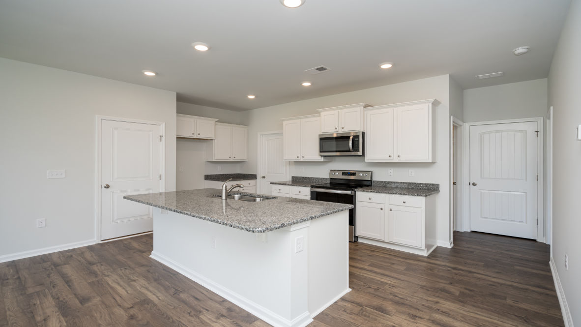 This new home kitchen features Stainless Steel Appliances, granite countertops and smooth-top electric range, microwave and dishwasher. Plenty of cabinet space.