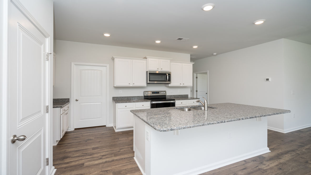 This new home kitchen features Stainless Steel Appliances, granite countertops and smooth-top electric range, microwave and dishwasher. Plenty of cabinet space.