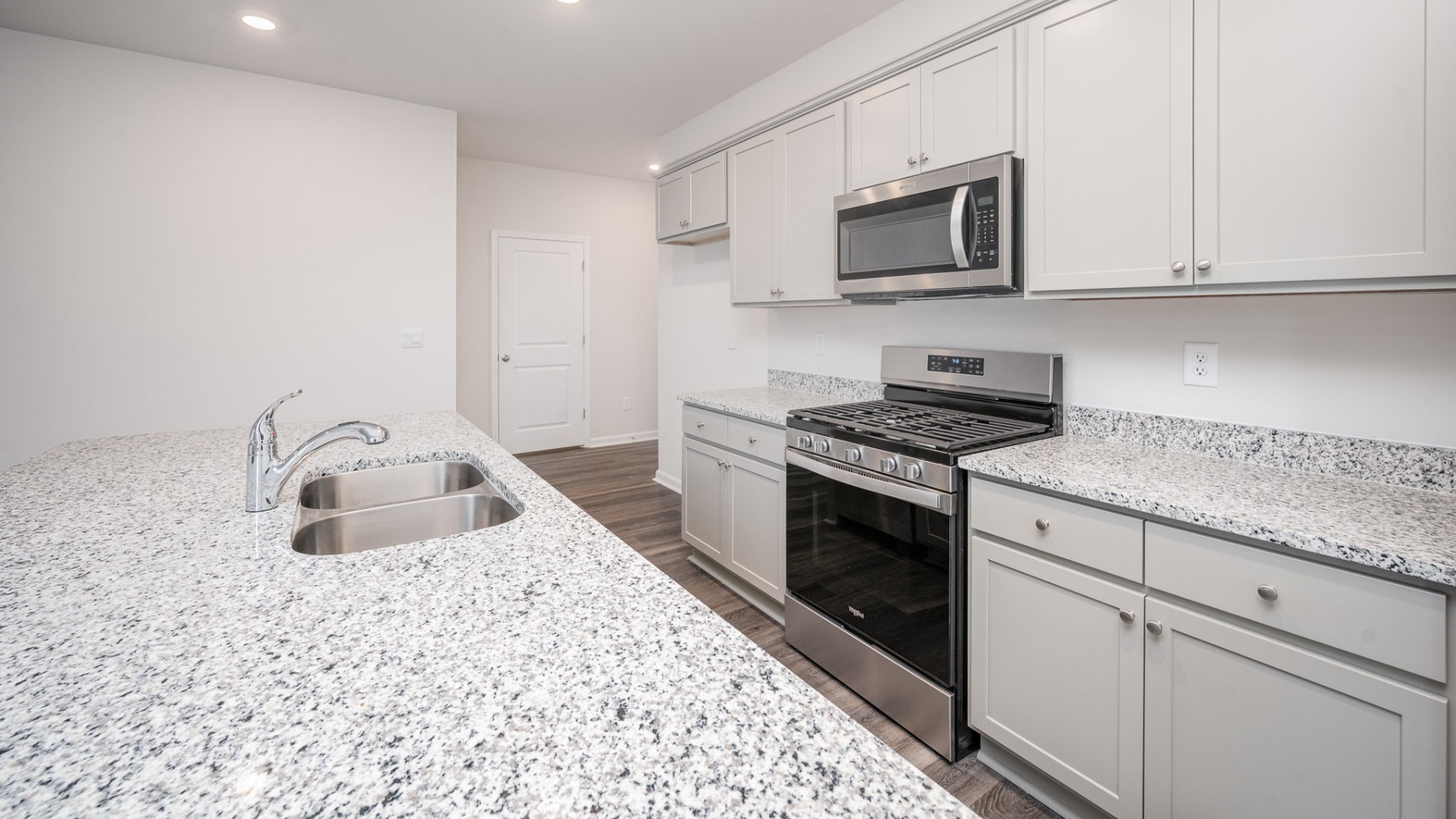 The kitchen features shaker-style cabinets, granite countertops, and stainless steel appliances, which are sure to both turn heads and make meal prep easy. You’ll never be too far from the action with the living and dining area right there.