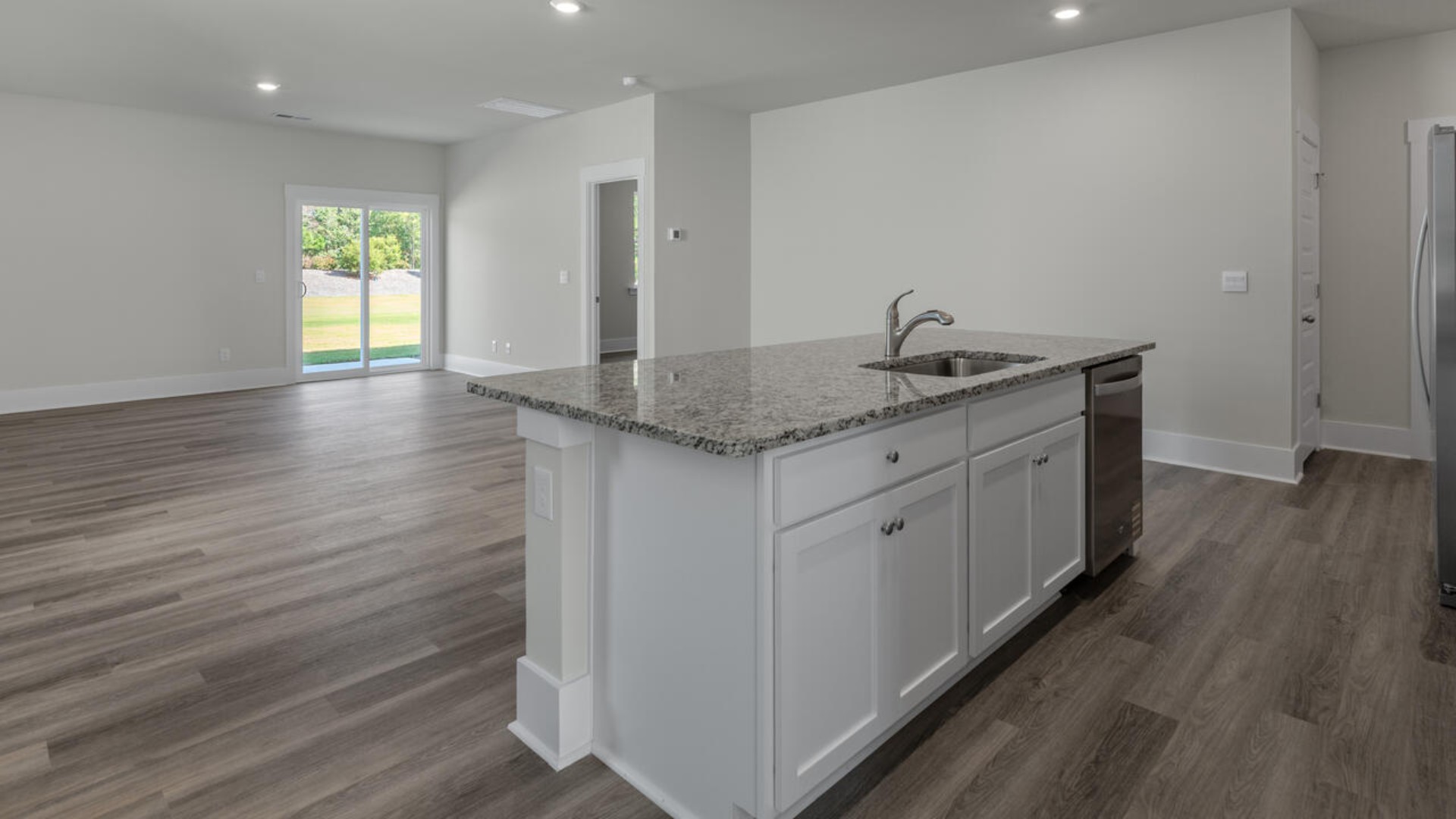 The kitchen features shaker-style cabinets, granite countertops, and stainless steel appliances, which are sure to both turn heads and make meal prep easy. You’ll never be too far from the action with the living and dining area right there.