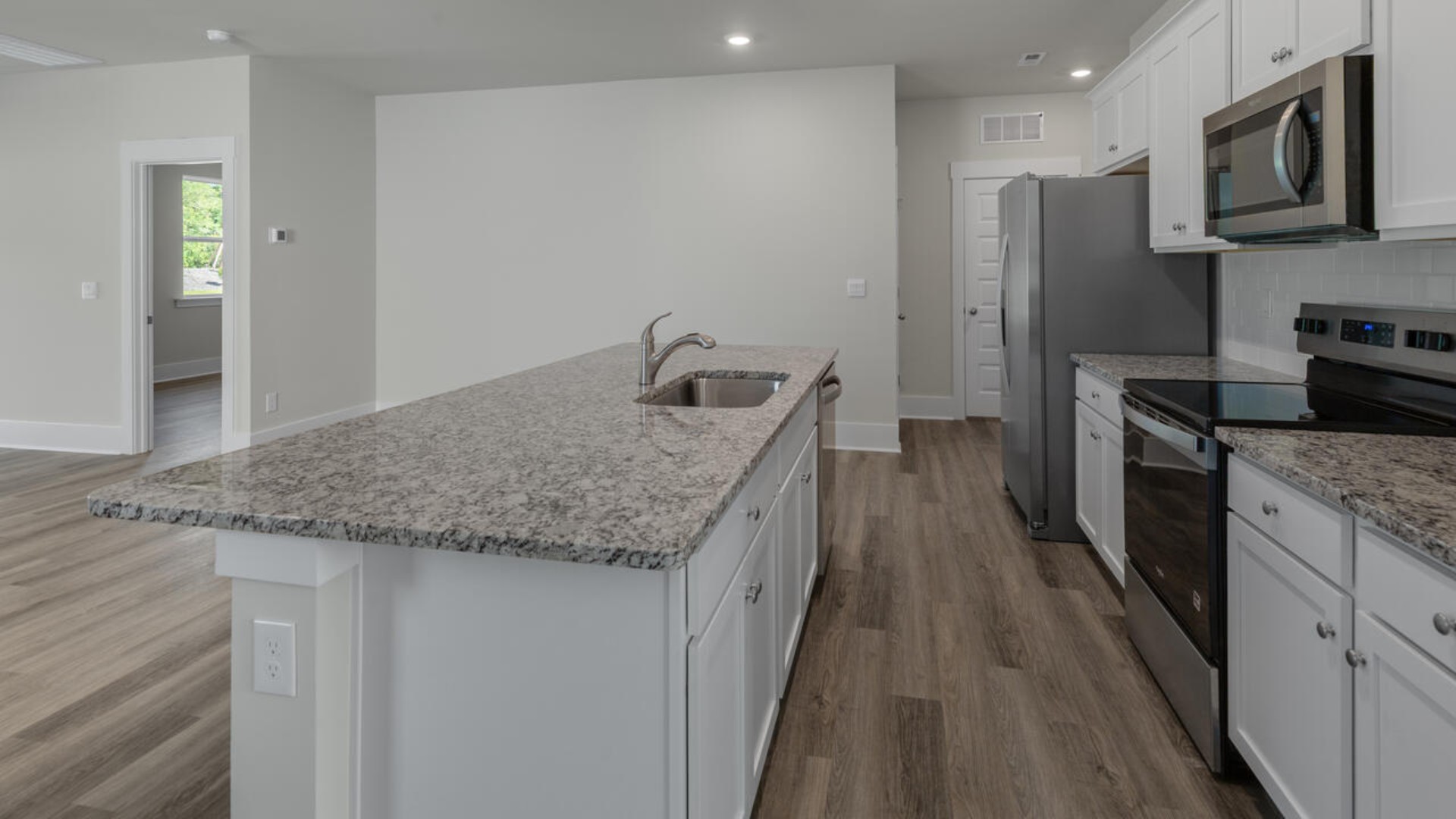 The kitchen features shaker-style cabinets, granite countertops, and stainless steel appliances, which are sure to both turn heads and make meal prep easy. You’ll never be too far from the action with the living and dining area right there.