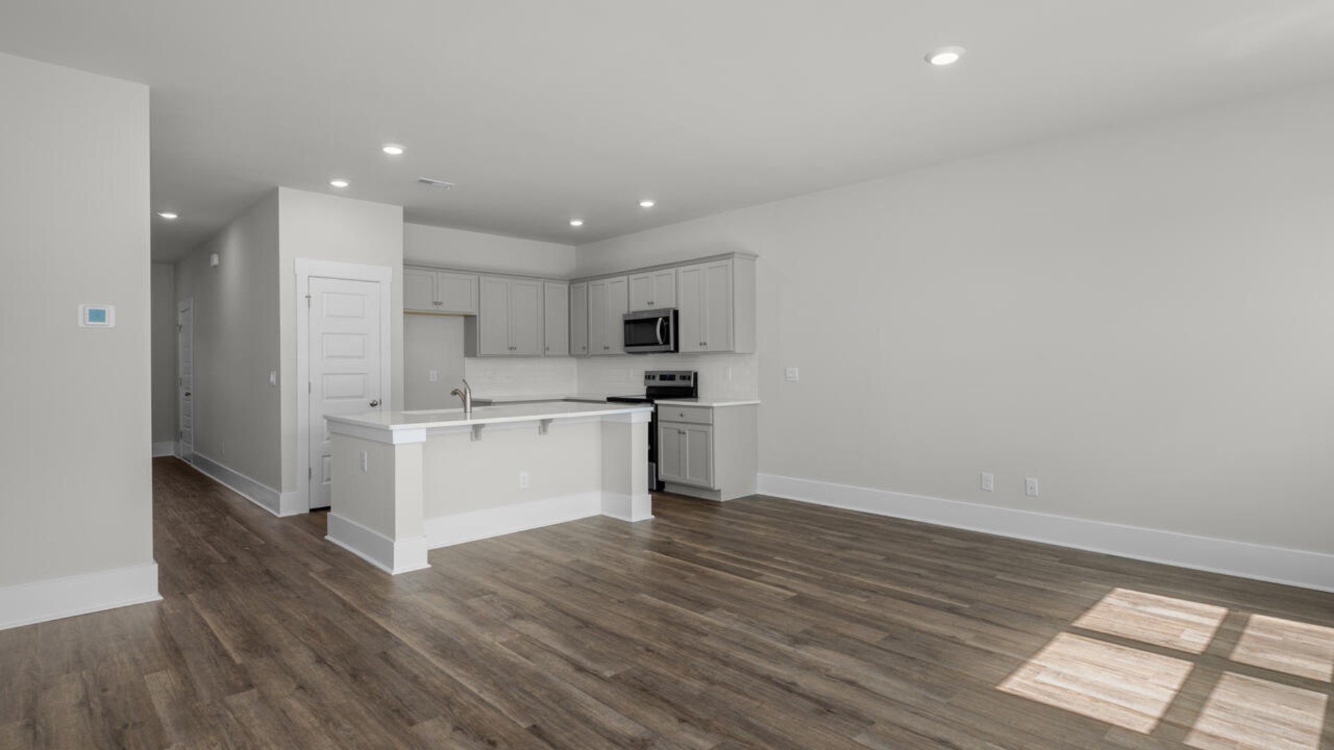 There is a powder room located under the stairs. The living area is an open concept, where your kitchen, living, and dining areas blend seamlessly into a space perfect for everyday living and entertaining.