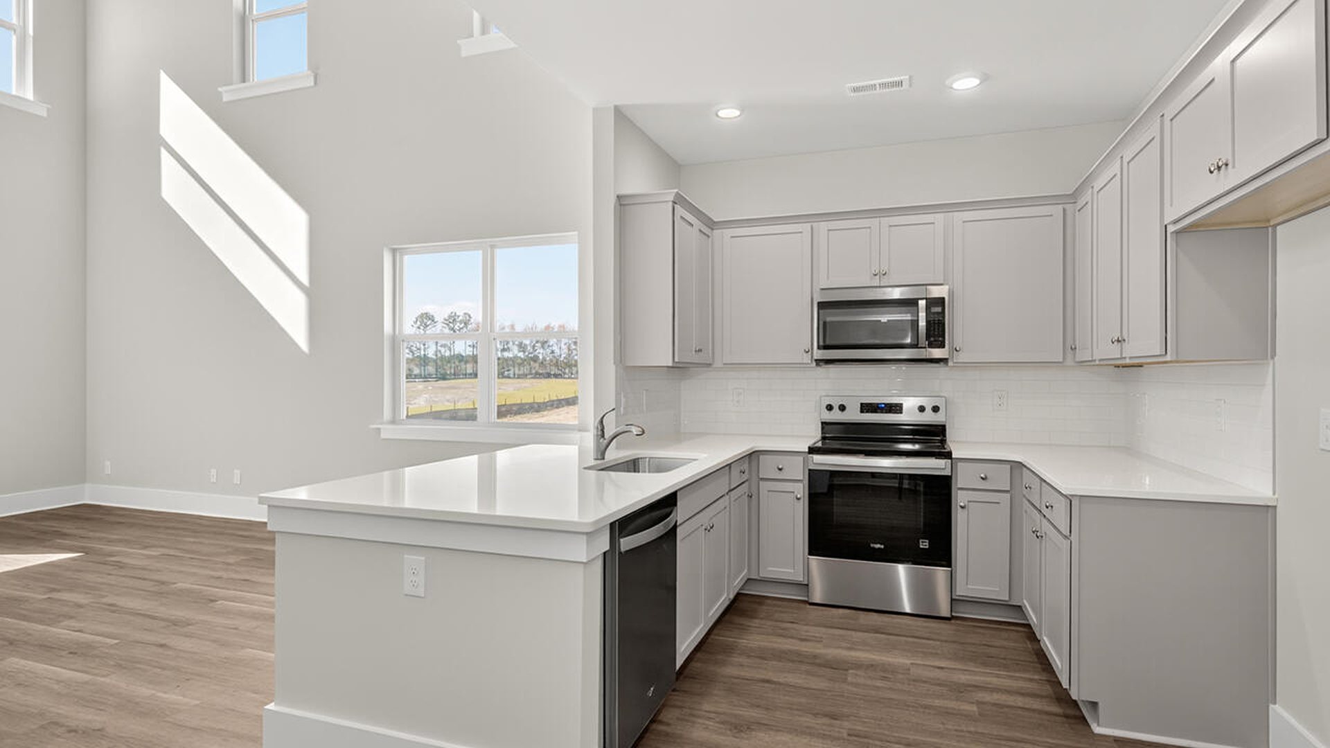 The open concept living room off the kitchen offers a feeling of grandeur with it's two-story ceilings and so much natural light to take in.