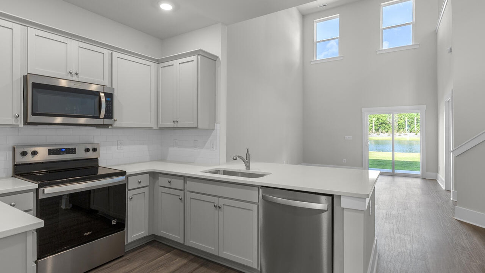 The kitchen features shaker-style cabinets, quartz countertops, and stainless-steel appliances, which are sure to both turn heads and make meal prep easy. You’ll never be too far from the action with the living and dining area right there.
