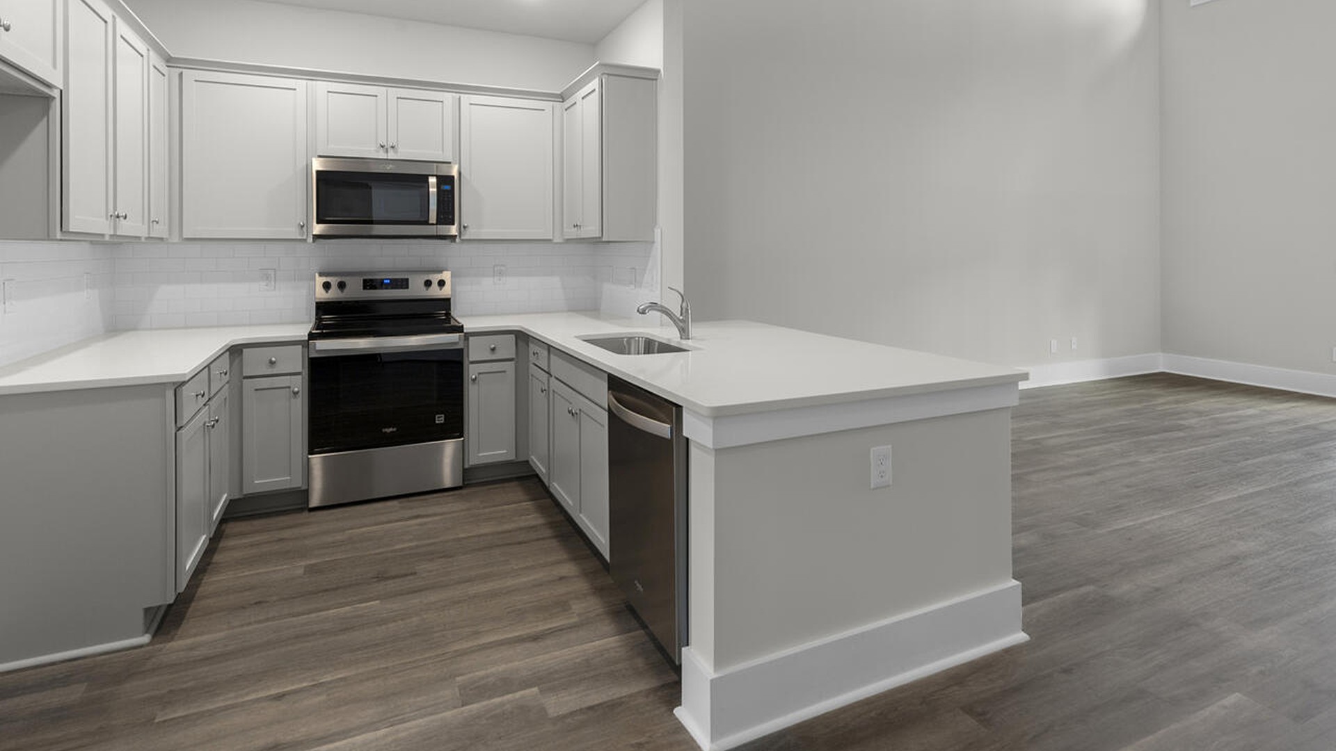 The kitchen features shaker-style cabinets, quartz countertops, and stainless-steel appliances, which are sure to both turn heads and make meal prep easy. You’ll never be too far from the action with the living and dining area right there.