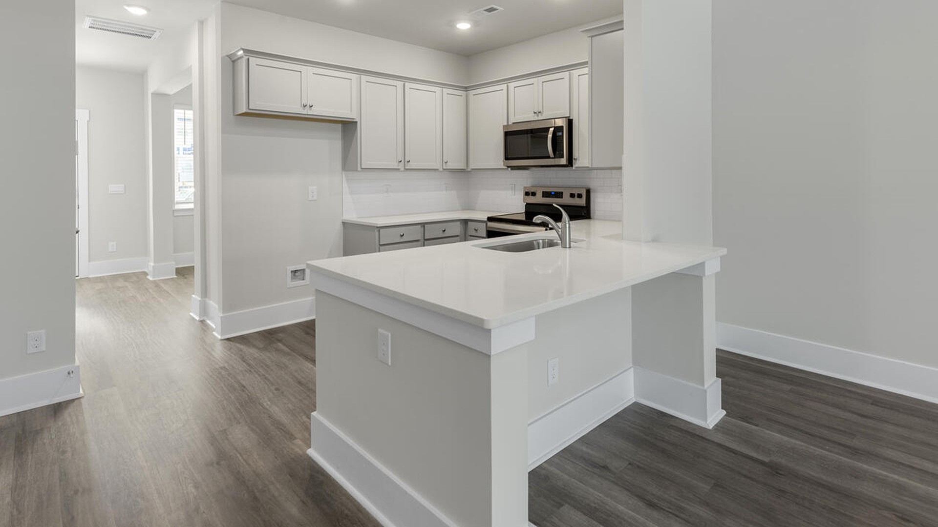 The kitchen features shaker-style cabinets, quartz countertops, and stainless-steel appliances, which are sure to both turn heads and make meal prep easy. You’ll never be too far from the action with the living and dining area right there.