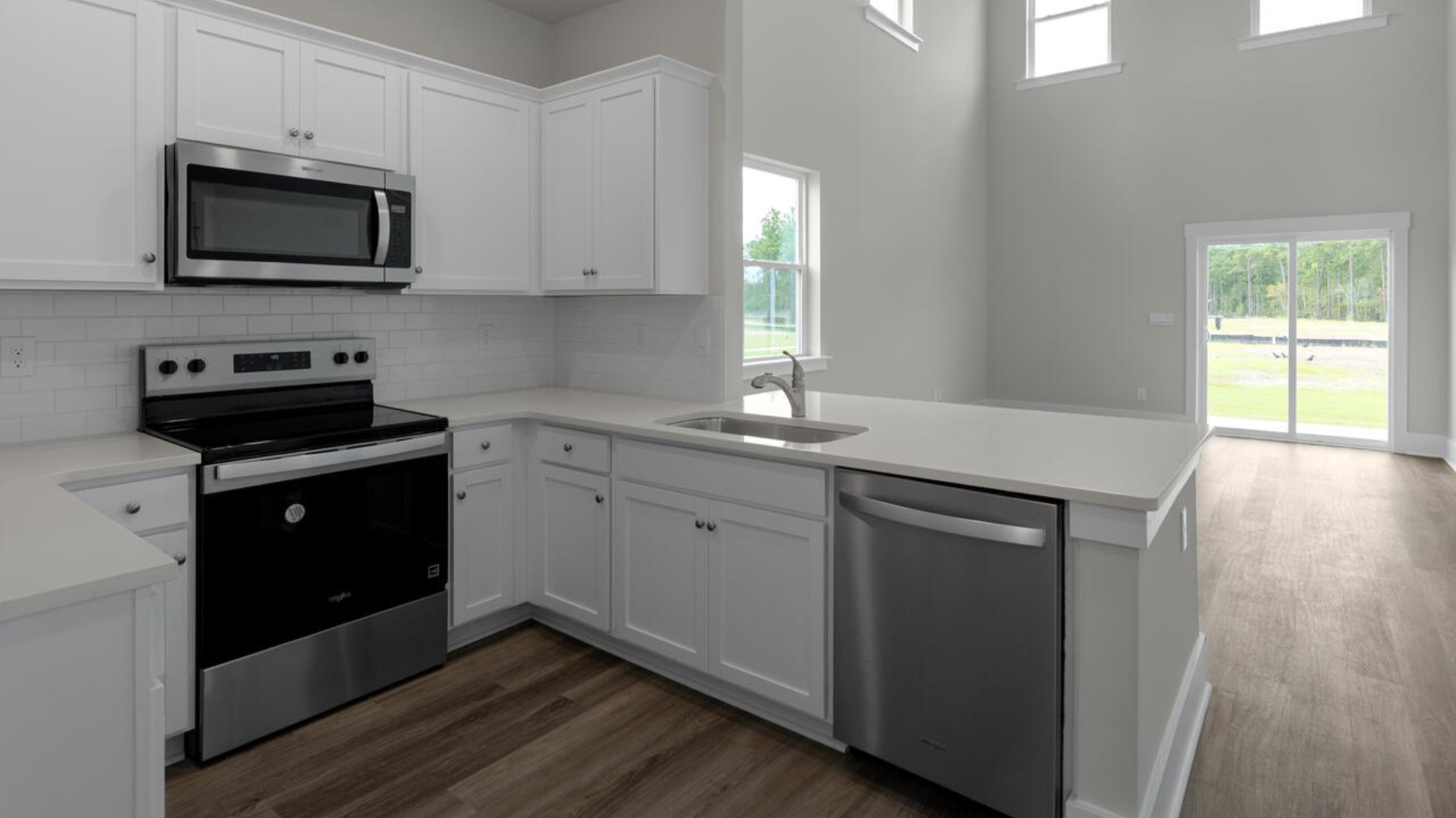 The kitchen features shaker-style cabinets, quartz countertops, and stainless steel appliances, which are sure to both turn heads and make meal prep easy. You’ll never be too far from the action with the living and dining area right there.