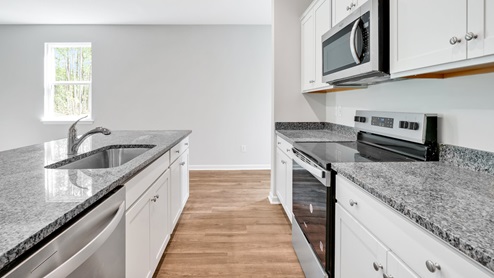 The kitchen features beautiful cabinets, granite countertops, and stainless steel appliances, which are sure to both turn heads and make meal prep easy. You’ll never be too far from the action with the living and dining area right there.