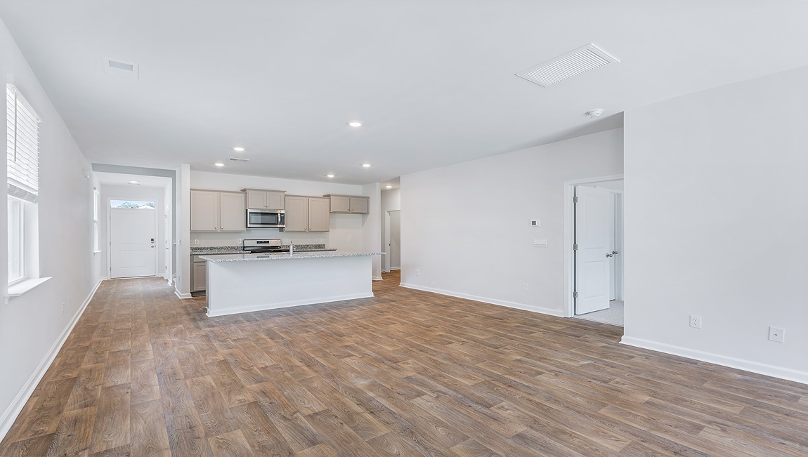 Entering the great room we find the dining area, family room and a wonderful cook's kitchen are all together for open living.