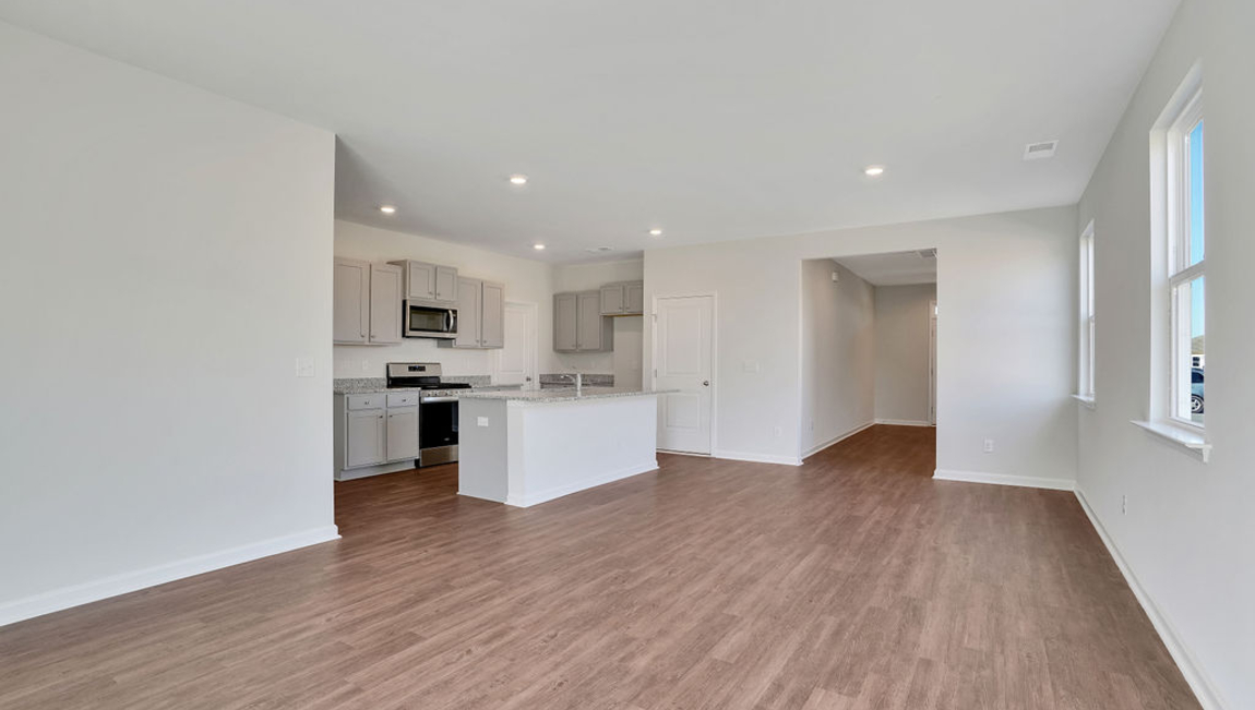 The chef’s kitchen has modern stainless steel appliances, granite countertops, ample cabinet space, a walk-in pantry, and a breakfast bar, perfect for cooking and casual dining. Adjacent to the kitchen is a bedroom, providing privacy and comfort.