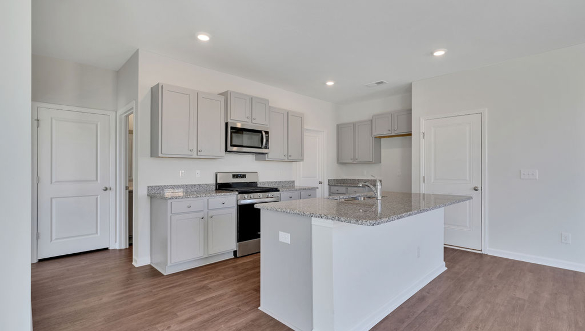 The chef’s kitchen has modern stainless steel appliances, granite countertops, ample cabinet space, a walk-in pantry, and a breakfast bar, perfect for cooking and casual dining. Adjacent to the kitchen is a bedroom, providing privacy and comfort.