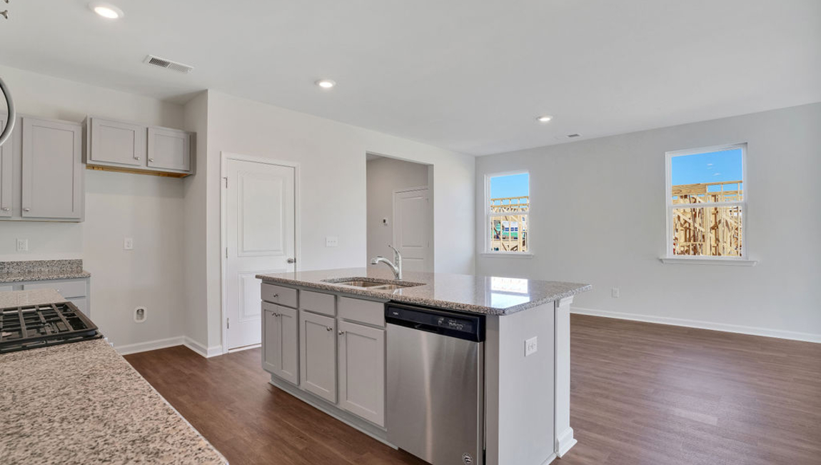 The chef’s kitchen has modern stainless steel appliances, granite countertops, ample cabinet space, a walk-in pantry, and a breakfast bar, perfect for cooking and casual dining. Adjacent to the kitchen is a bedroom, providing privacy and comfort.
