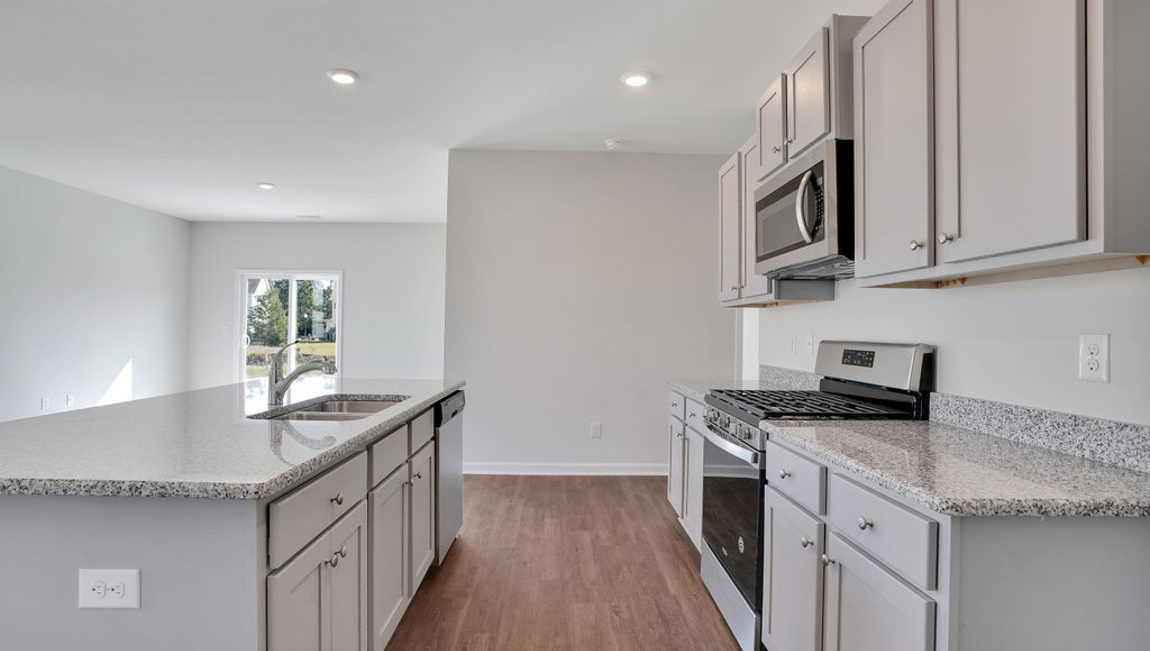 The chef’s kitchen has modern stainless steel appliances, granite countertops, ample cabinet space, a walk-in pantry, and a breakfast bar, perfect for cooking and casual dining. Adjacent to the kitchen is a bedroom, providing privacy and comfort.