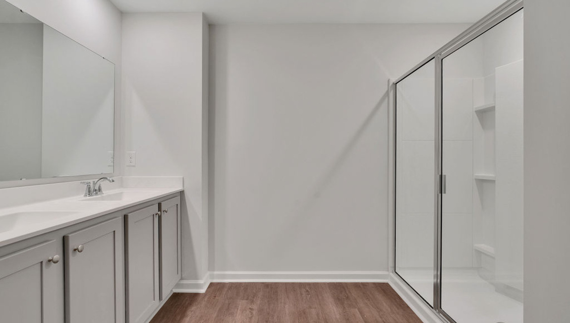 The home features a primary suite with a walk-in closet and an en suite bathroom featuring a shower with dual vanities. The additional three bathrooms are spacious and have access to a secondary bathroom.