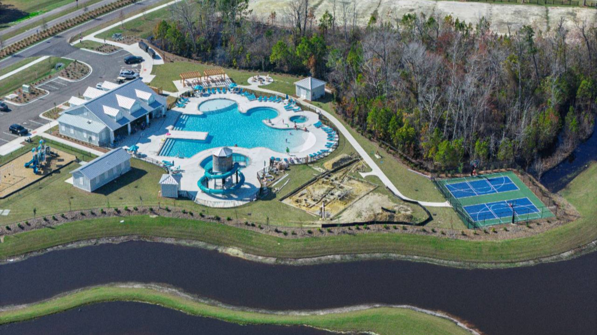 The amenity center that includes a swimming pool, multi-sport court, splashpad, playground, and fire pit, ensuring a well-rounded and enjoyable living experience.