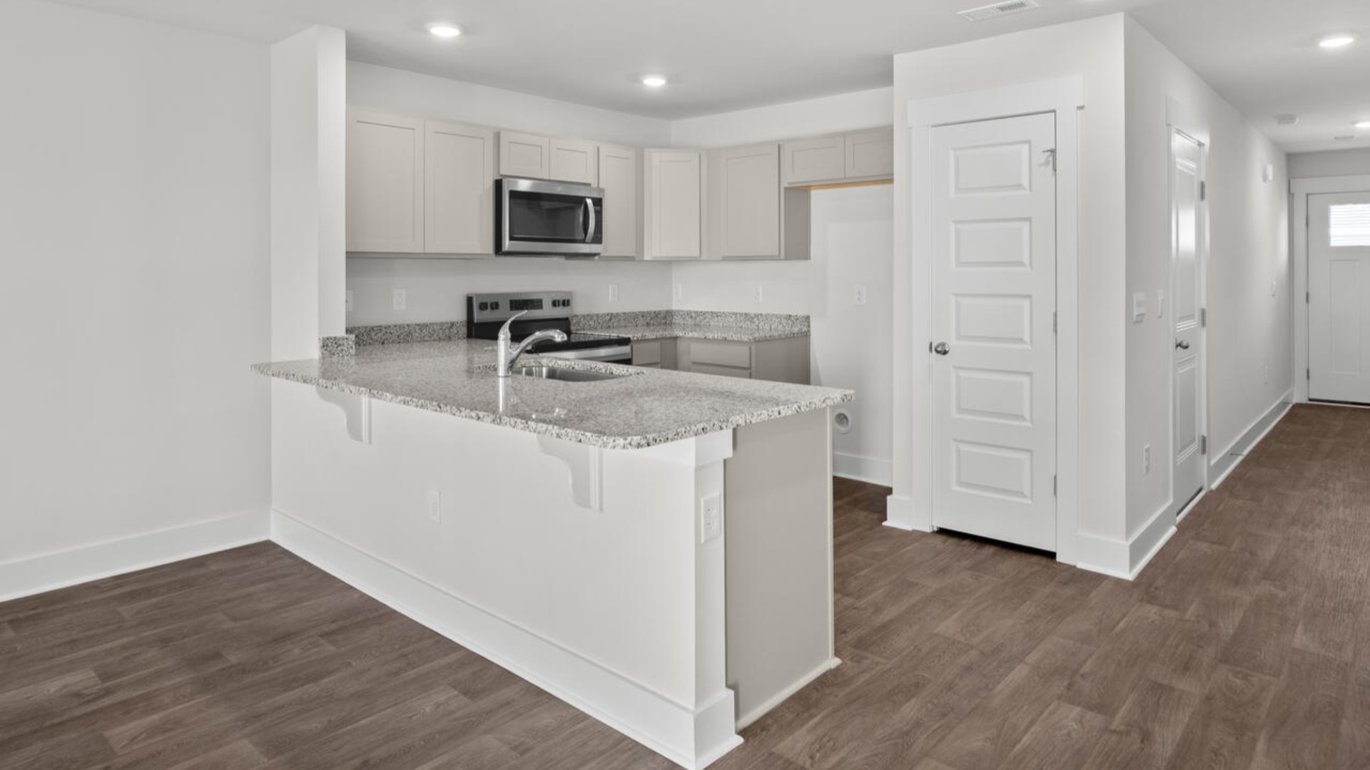 The kitchen overlooks the dining and living spaces, ideal for entertaining guests or enjoying family time while preparing meals with new stainless-steel appliances, walk-in pantry and granite countertops.