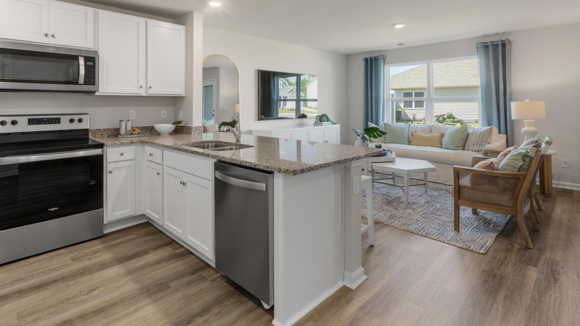 The kitchen overlooks the dining and living spaces, ideal for entertaining guests or enjoying family time while preparing meals with new stainless-steel appliances, walk-in pantry and granite countertops.