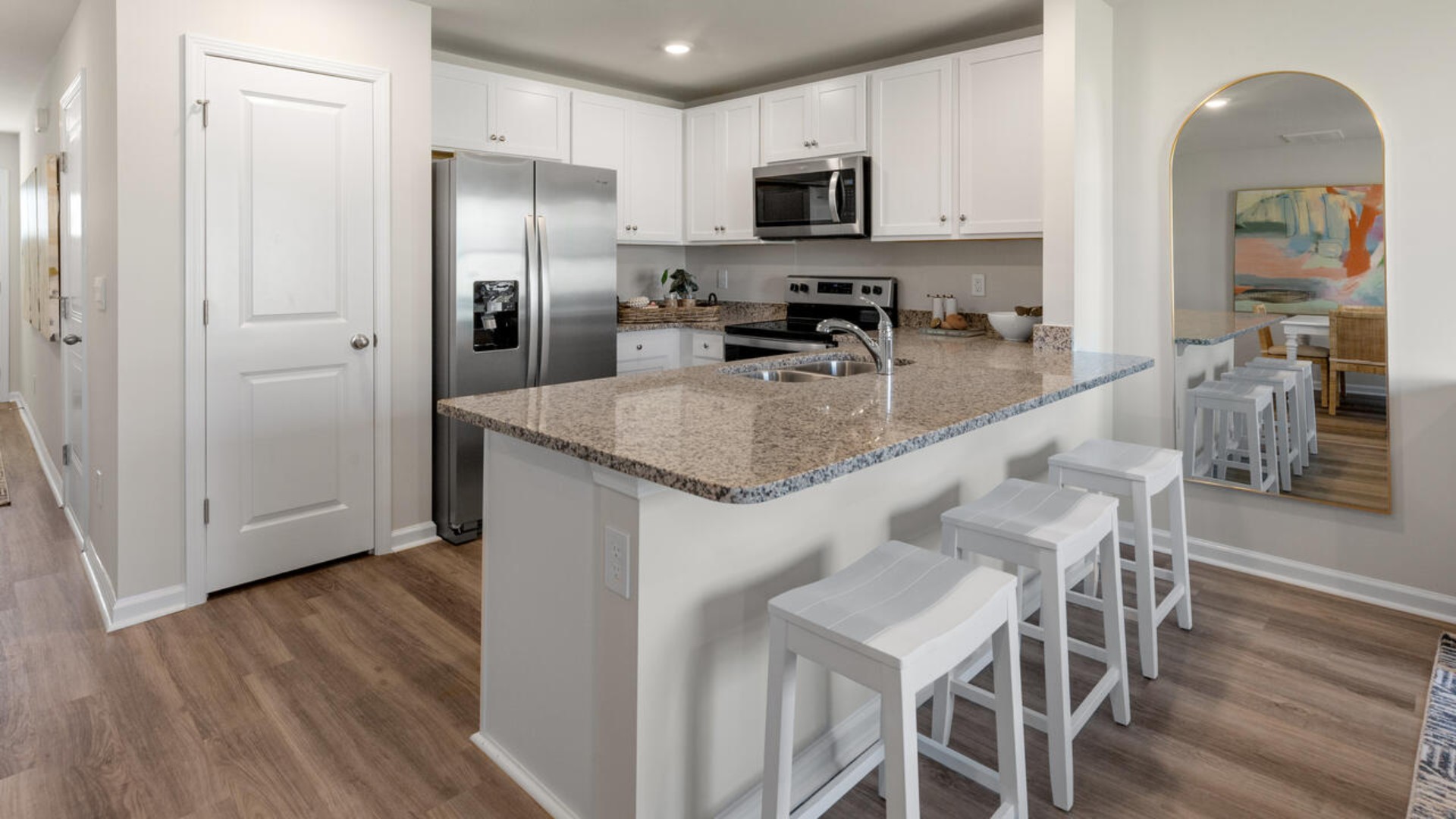 The kitchen overlooks the dining and living spaces, ideal for entertaining guests or enjoying family time while preparing meals with new stainless-steel appliances, walk-in pantry and granite countertops.