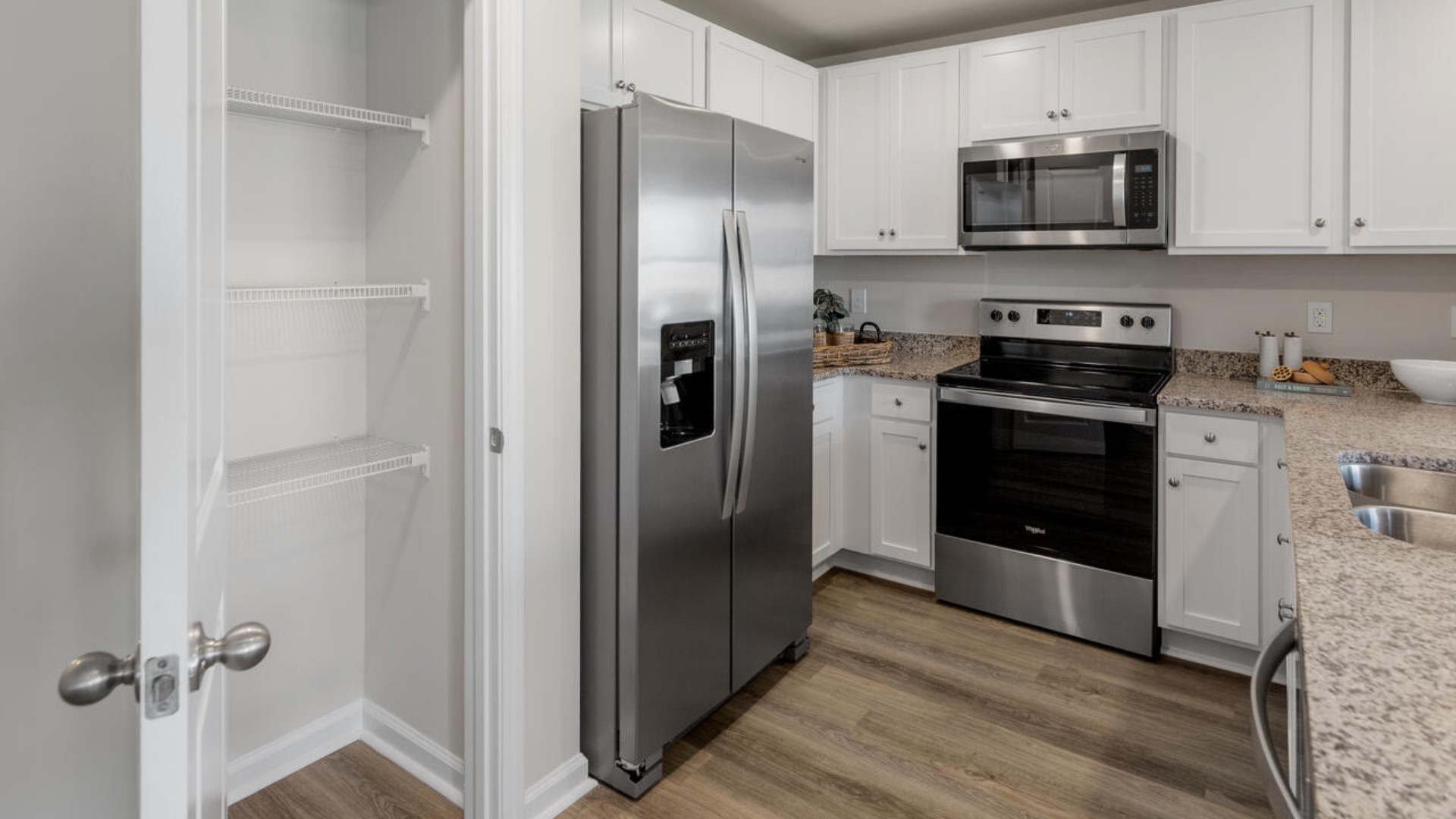 The kitchen overlooks the dining and living spaces, ideal for entertaining guests or enjoying family time while preparing meals with new stainless-steel appliances, walk-in pantry and granite countertops.