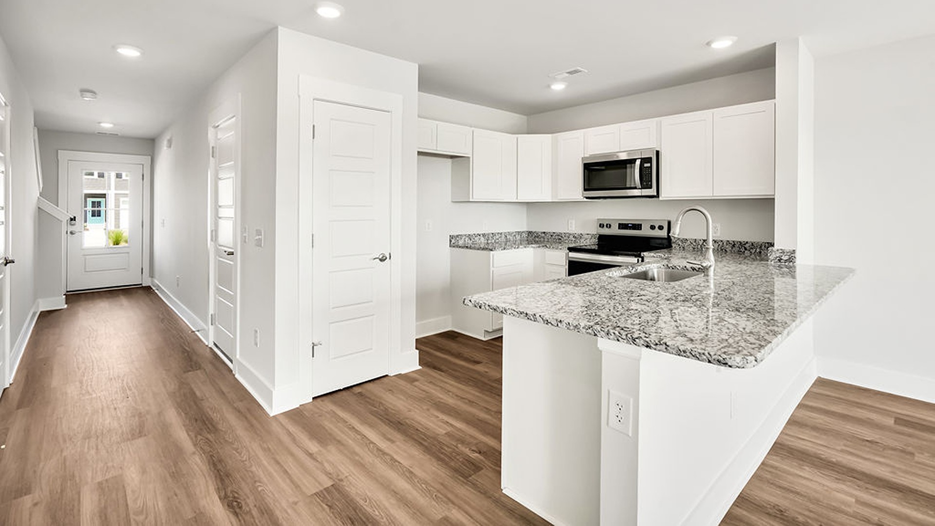 The kitchen overlooks the dining and living spaces, ideal for entertaining guests or enjoying family time while preparing meals with new stainless-steel appliances and granite countertops.