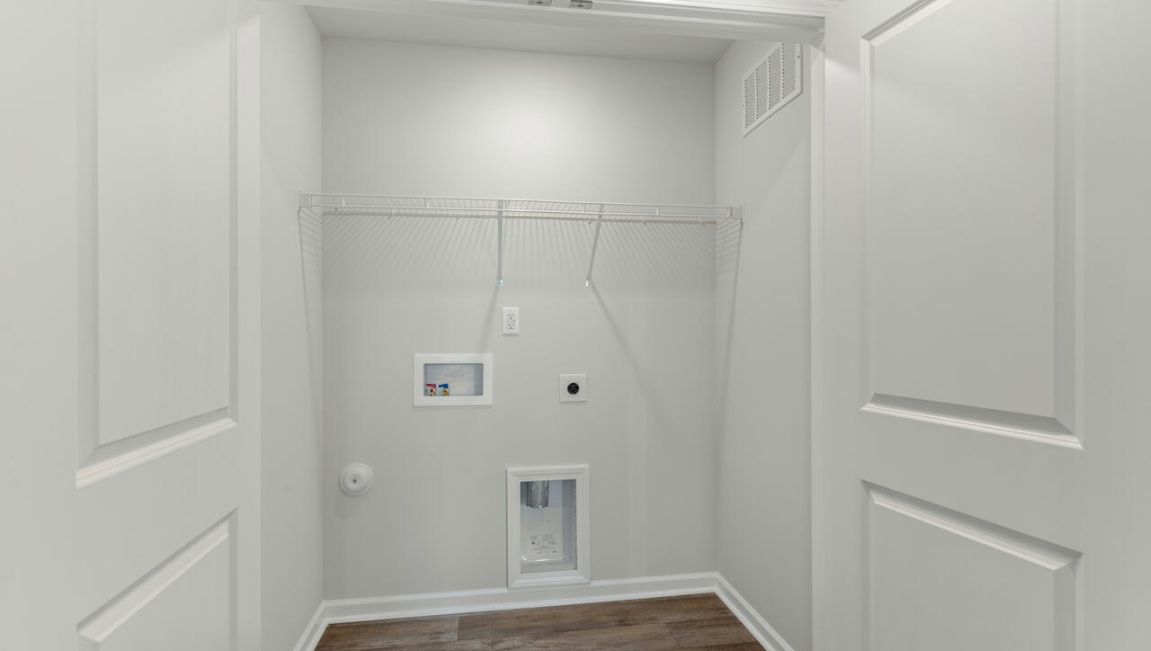 The second floor features the primary bedroom with a walk-in closet and double vanities. It also includes two additional bedrooms, a shared bathroom, and a laundry room for convenience.