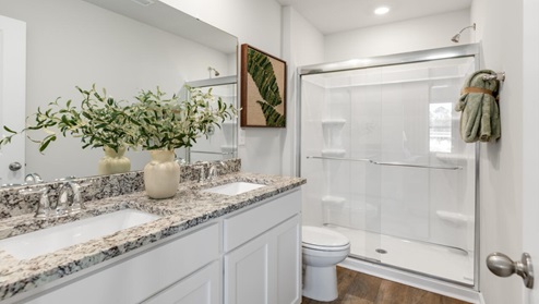 The first floor features the primary bedroom with a walk-in closet and double vanities