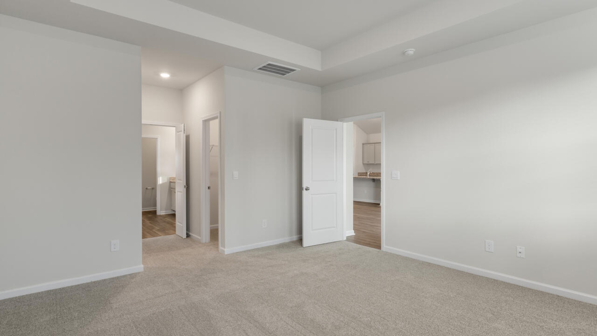 The split bedroom plan creates a private primary bedroom suite featuring two walk-in closets and a spacious en suite bath.