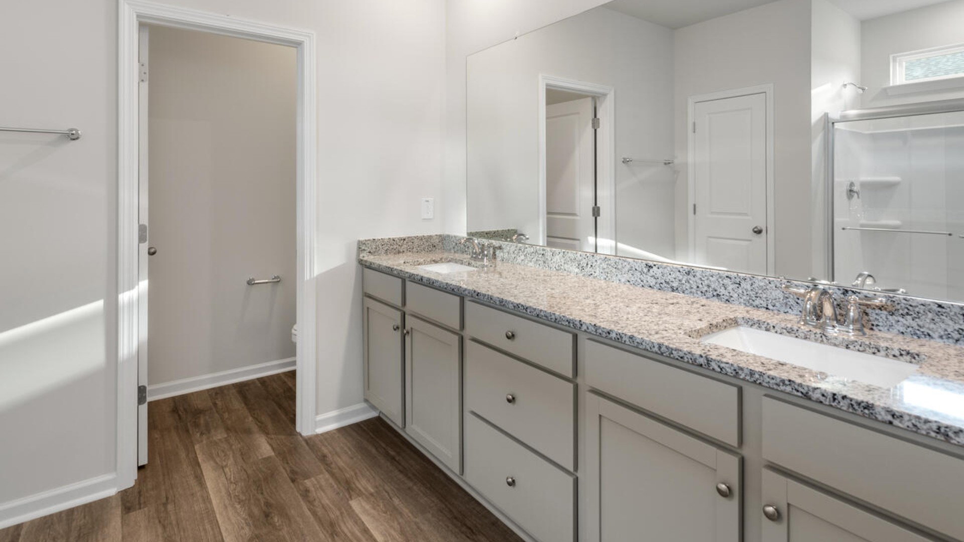 The split bedroom plan creates a private primary bedroom suite featuring two walk-in closets and a spacious en suite bath.