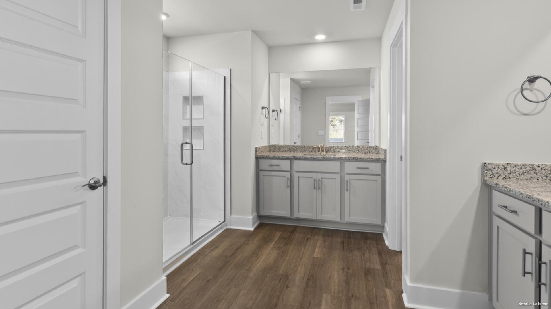 The primary suite bath features a step-in 5' shower and a dual vanity.