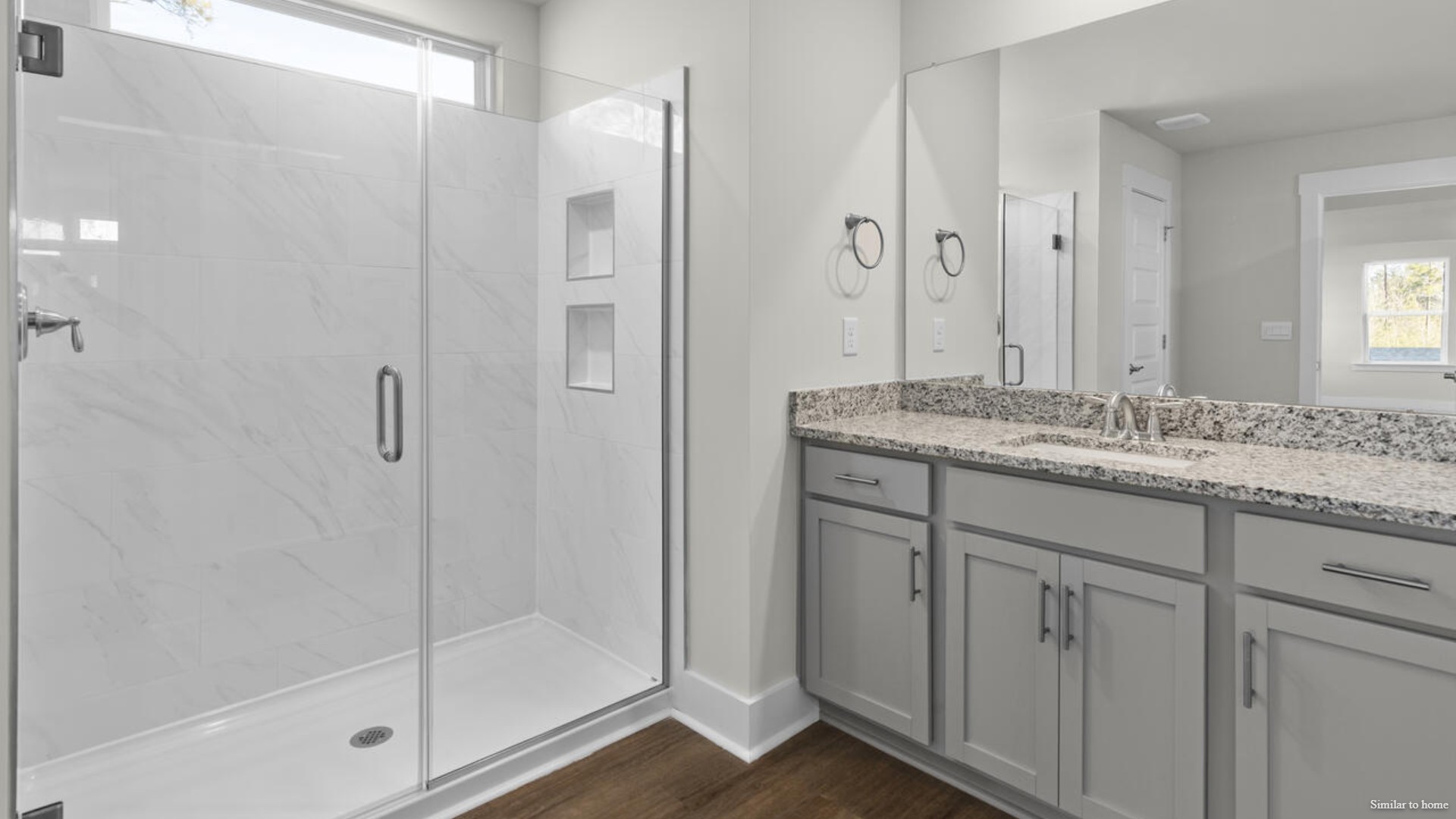 The primary suite bath features a step-in 5' shower and a dual vanity.
