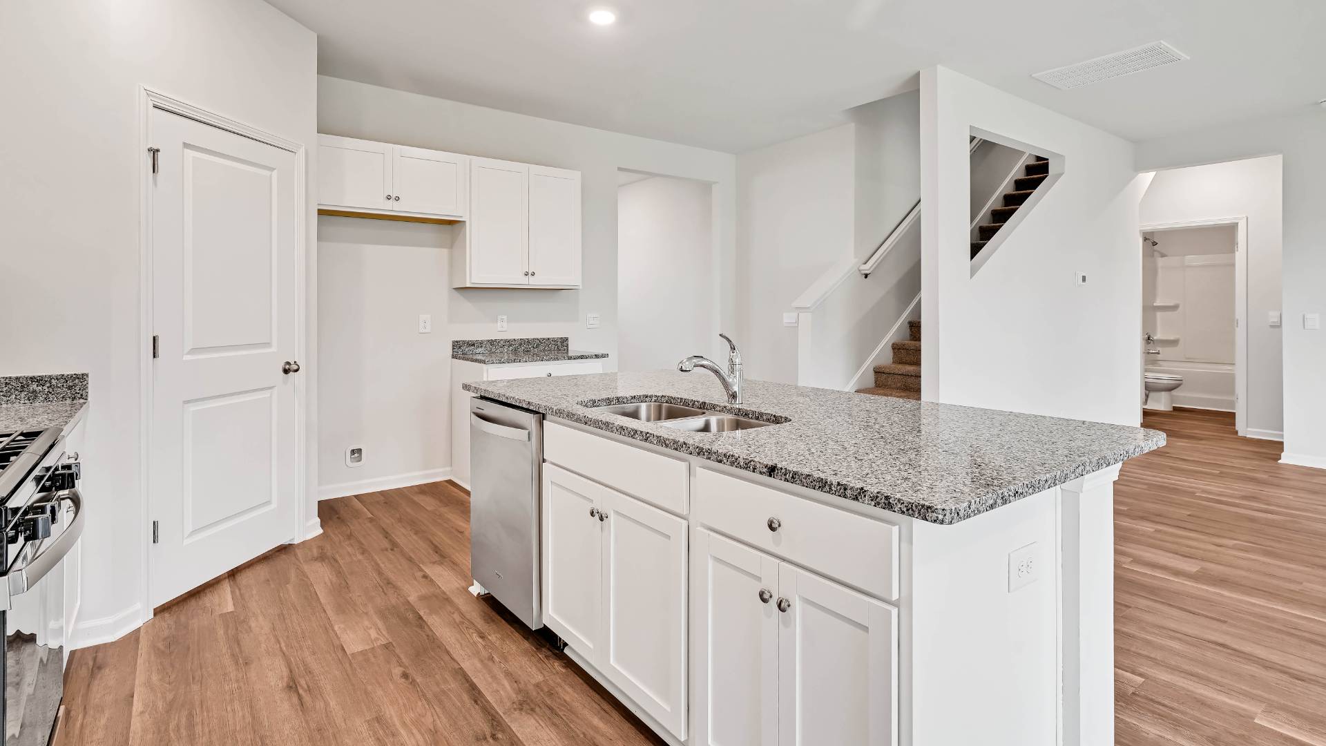 The gourmet kitchen has an oversized island for extra seating and a large pantry, and it opens to the dining area and a spacious living room. A bedroom with a full bathroom completes the main level.
