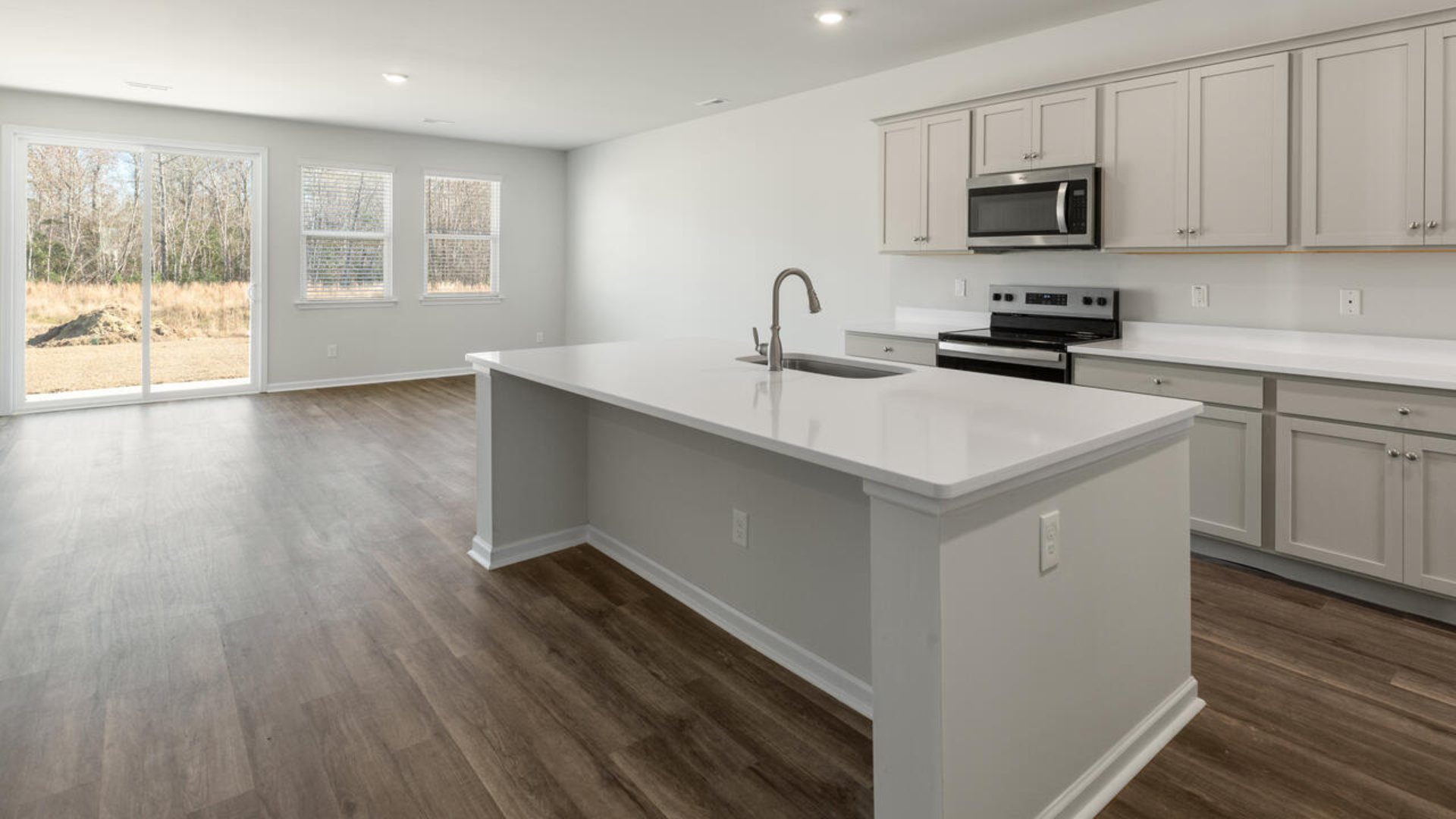 Our Tillman plan is a spacious home with a formal dining room, open concept kitchen with granite countertops, stainless steel appliances and family room with additional seating at the large kitchen island, and a first floor primary bedroom retreat.