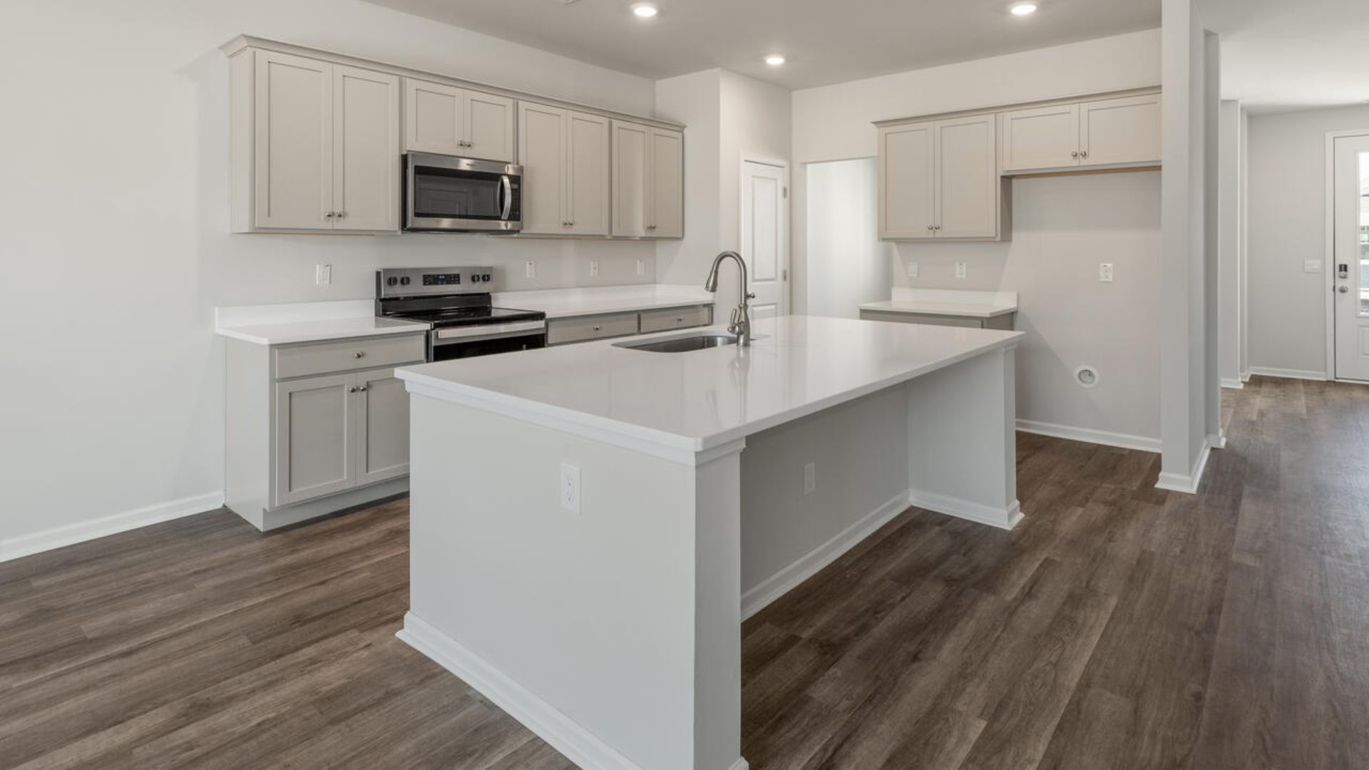 Our Tillman plan is a spacious home with a formal dining room, open concept kitchen with granite countertops, stainless steel appliances and family room with additional seating at the large kitchen island, and a first floor primary bedroom retreat.
