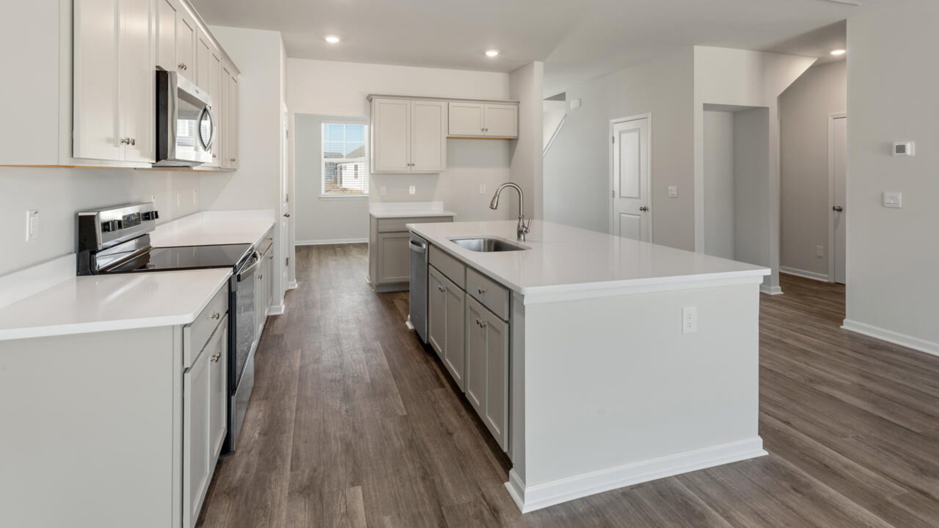 Our Tillman plan is a spacious home with a formal dining room, open concept kitchen with granite countertops, stainless steel appliances and family room with additional seating at the large kitchen island, and a first floor primary bedroom retreat.