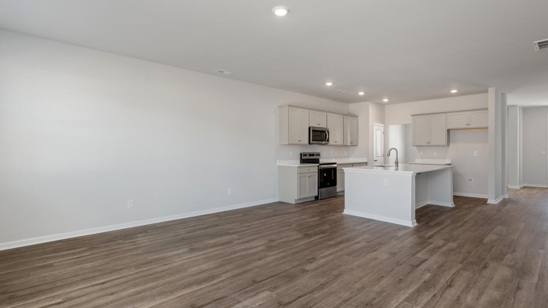 Our Tillman plan is a spacious home with a formal dining room, open concept kitchen with granite countertops, stainless steel appliances and family room with additional seating at the large kitchen island, and a first floor primary bedroom retreat.