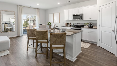 The main level features a flex room adjacent to the foyer, ideal for a formal dining room or home office. The gourmet kitchen has an oversized island for extra seating and a large pantry, and it opens to the dining area and a spacious living room. A bedroom with a full bathroom completes the main level.