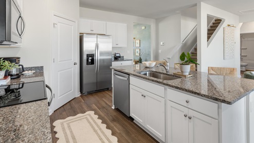 The main level features a flex room adjacent to the foyer, ideal for a formal dining room or home office. The gourmet kitchen has an oversized island for extra seating and a large pantry, and it opens to the dining area and a spacious living room. A bedroom with a full bathroom completes the main level.