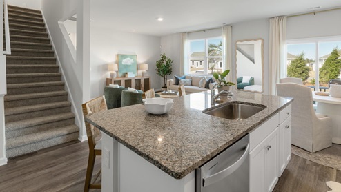 The main level features a flex room adjacent to the foyer, ideal for a formal dining room or home office. The gourmet kitchen has an oversized island for extra seating and a large pantry, and it opens to the dining area and a spacious living room. A bedroom with a full bathroom completes the main level.