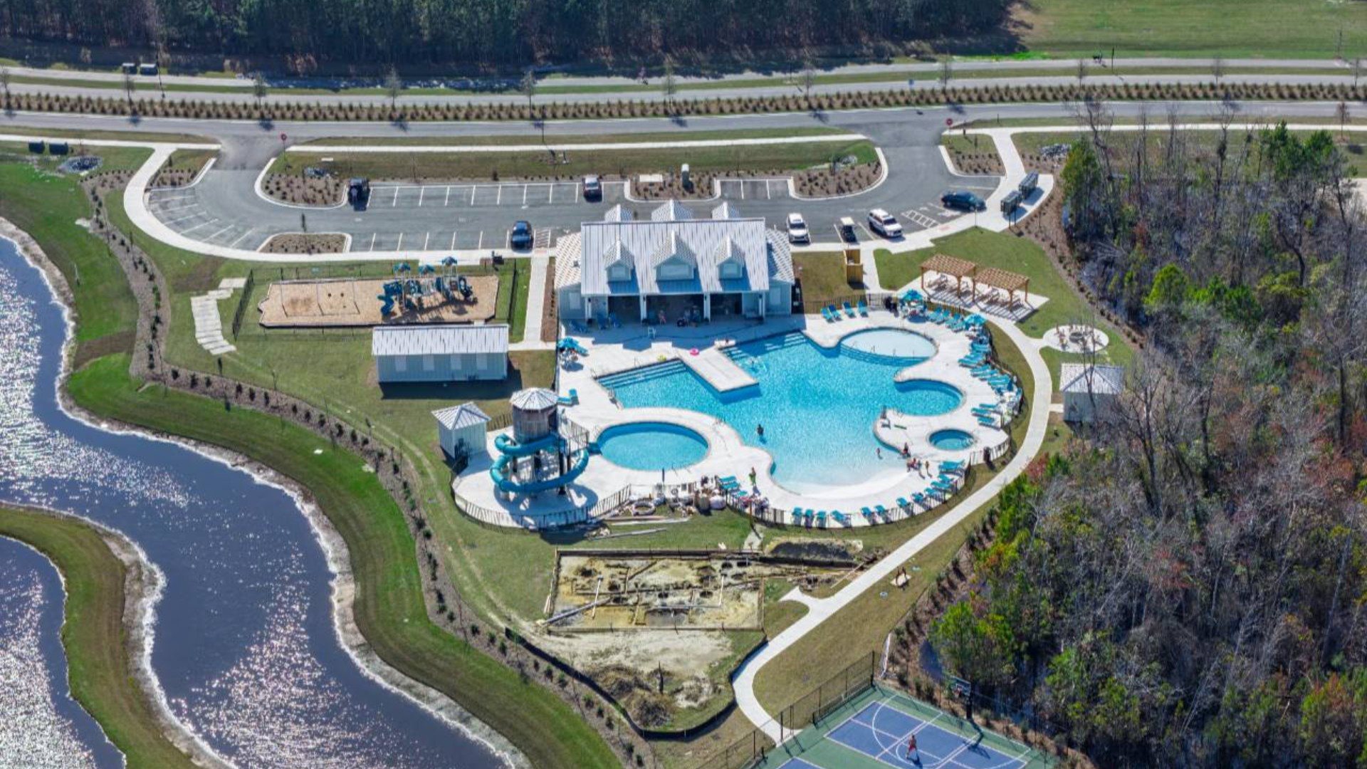 The amenity center that includes a swimming pool, multi-sport court, splashpad, playground, and fire pit, ensuring a well-rounded and enjoyable living experience.