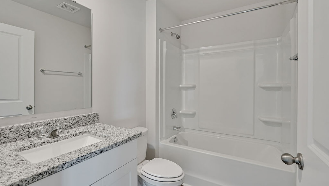 spacious primary suite upstairs features two walk-in closets, a spa-like bathroom with a double vanity, stand-up shower, and private water closet. Granite countertops are included in the bathroom and kitchen.