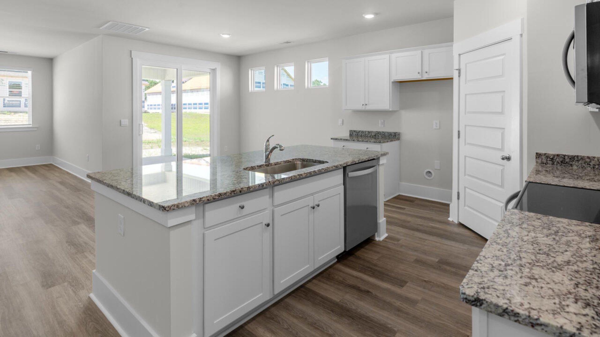 This home boasts stainless steel appliances, a large granite kitchen island that overlooks the dining area and patio, as well as a 45-degree angle pantry for ample food storage