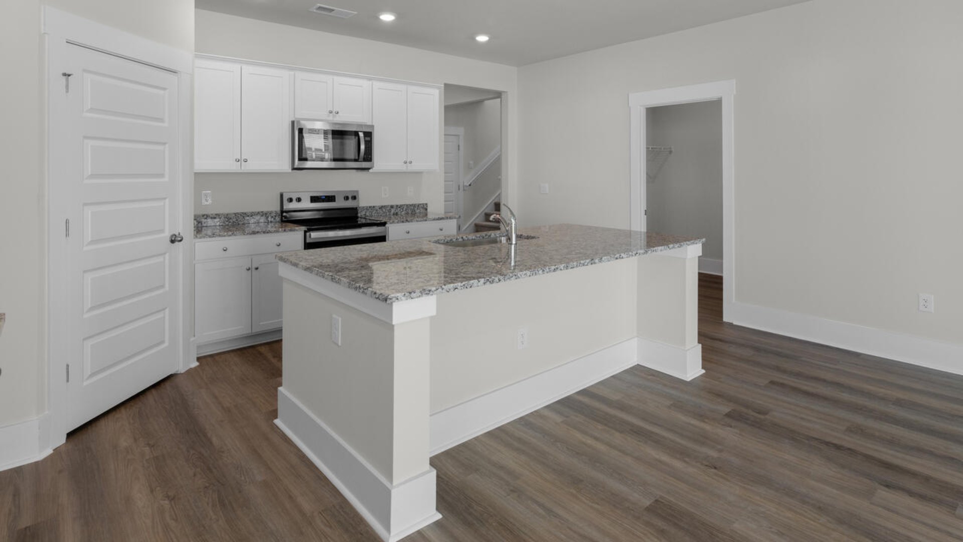 This home boasts stainless steel appliances, a large granite kitchen island that overlooks the dining area and patio, as well as a 45-degree angle pantry for ample food storage